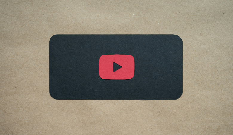 YouTube Play Symbol vor beigem Hintergrund