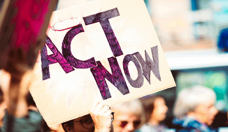 Symbolbild: Protestkundgebung bei der eine Person ein Schild mit der Aufschrift "Act Not" hochhält